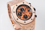 Rose gold-tone watch angled view with orange dial and black subdials
