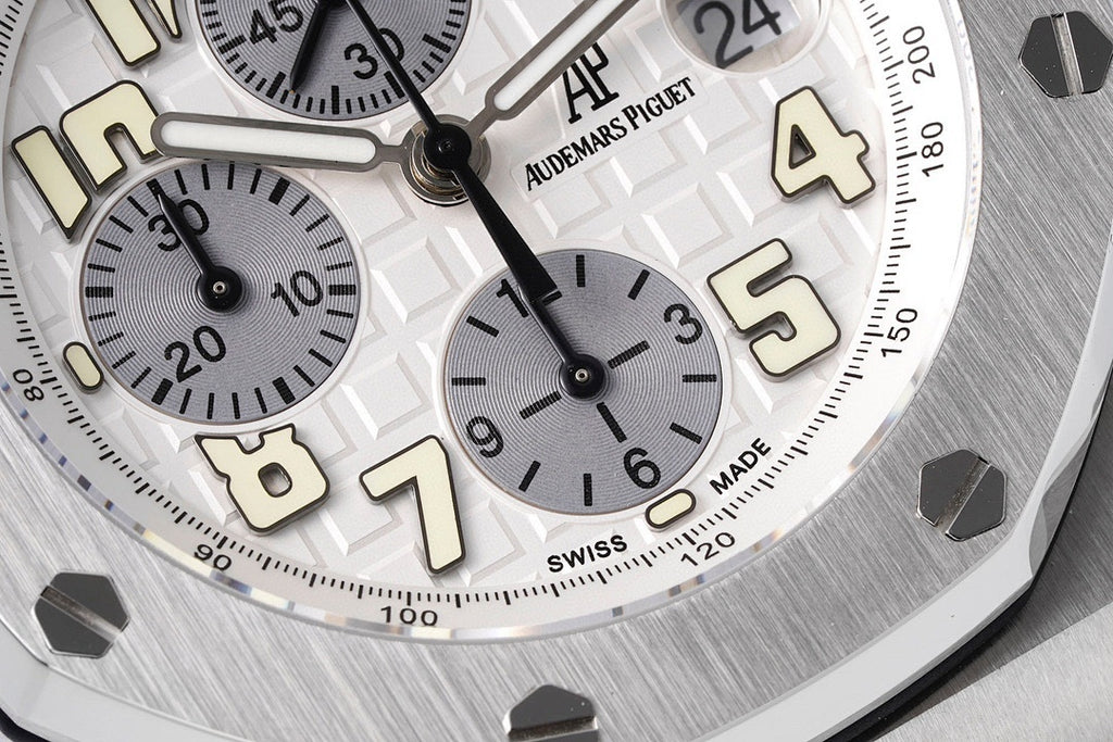 Close-up of white dial with Arabic numerals, subdials, and black hands
