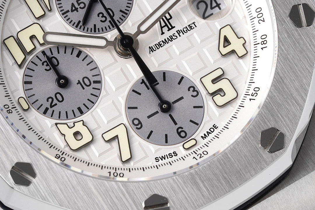 Close-up of white dial with Arabic numerals, subdials, and black hands