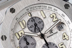Tachymeter scale and dial markings with cream accents on silver-tone watch