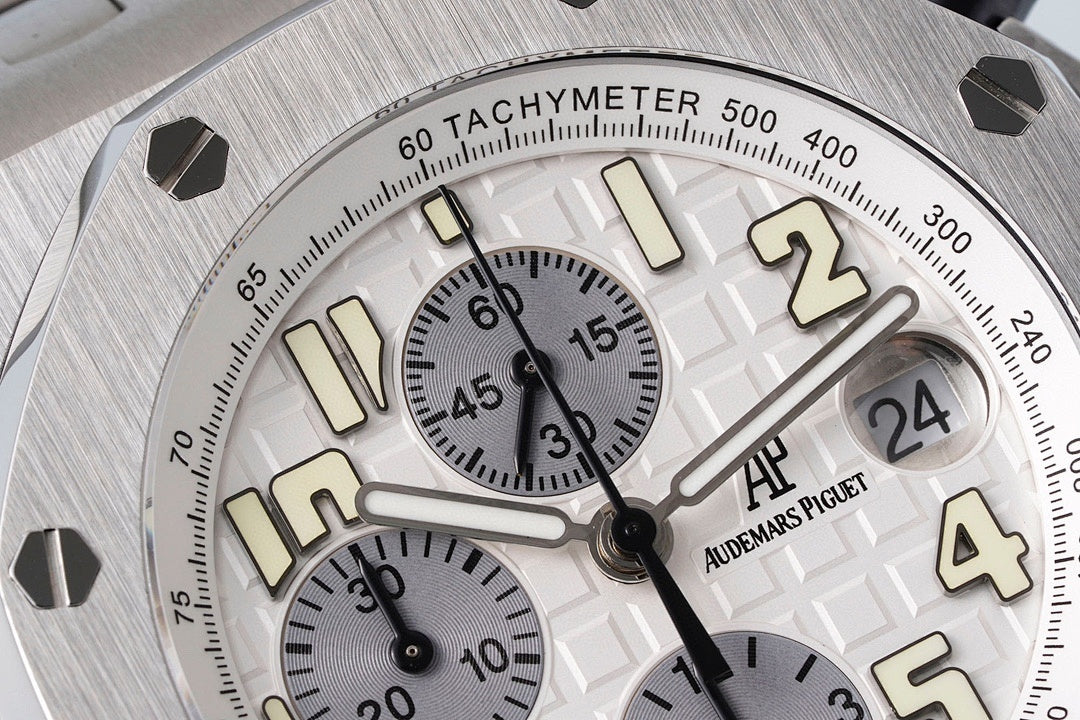 Tachymeter scale and dial markings with cream accents on silver-tone watch