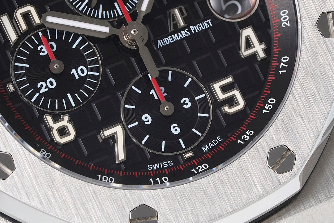 Black dial chronograph watch with red accents, tachymeter ring, and Arabic numerals