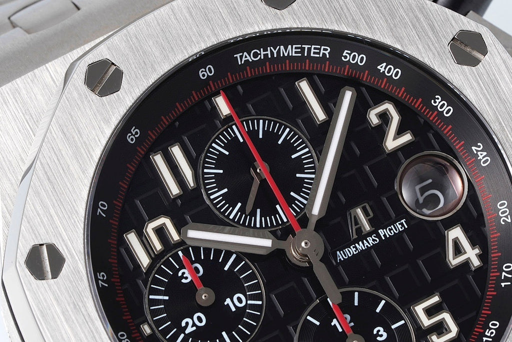 Close-up of black tachymeter chronograph dial with red seconds hand and subdial