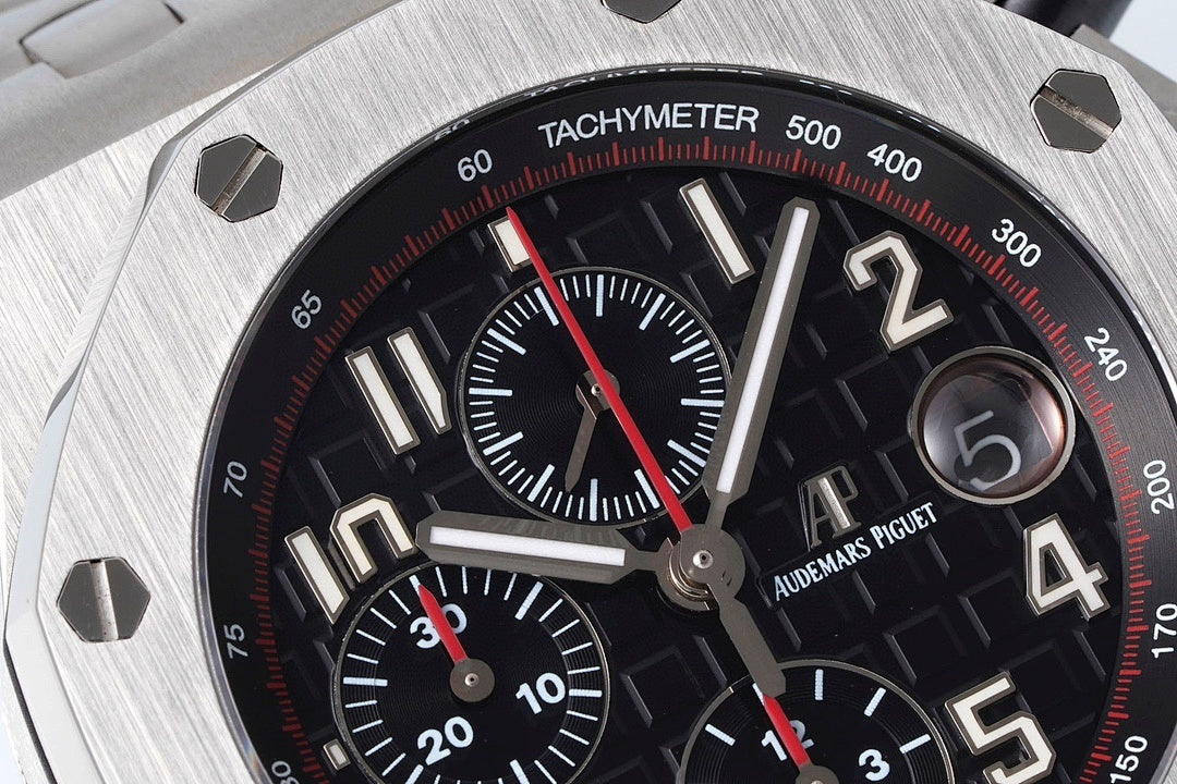 Close-up of black tachymeter chronograph dial with red seconds hand and subdial