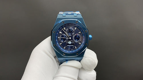 Audemars Piguet blue chronograph watch with bracelet, held in white gloves