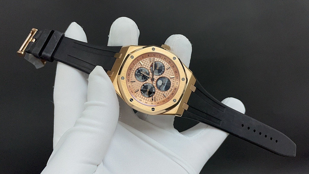 Gold-tone wristwatch with black rubber strap and champagne dial with four subdials