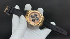 Gold-tone wristwatch with black rubber strap and champagne dial with four subdials