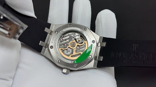 Audemars Piguet watch side view, open caseback with visible movement, black strap