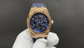 Audemars Piguet Royal Oak watch, gold case, blue dial, blue leather strap on white glove.
