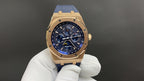 Audemars Piguet Royal Oak watch, gold case, blue dial, blue leather strap on white glove.
