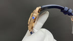 Gold Royal Oak watch crown side view, blue strap, on white glove.