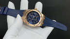 Gold Royal Oak watch front with blue strap, angled view on white glove.