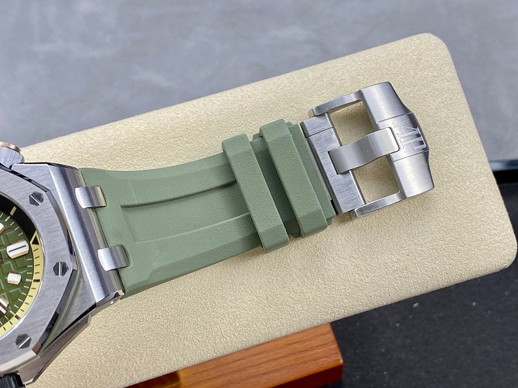 Green rubber watch strap with metal deployant clasp, angled view