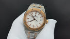 Audemars Piguet watch with gold bezel, champagne-white dial, and metal bracelet
