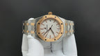 Audemars Piguet watch front view with gold accents, white dial, and linked bracelet