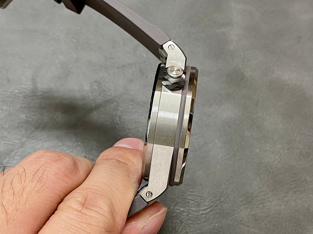Audemars Piguet Royal Oak watch case and bezel from the side, hand holding the strap