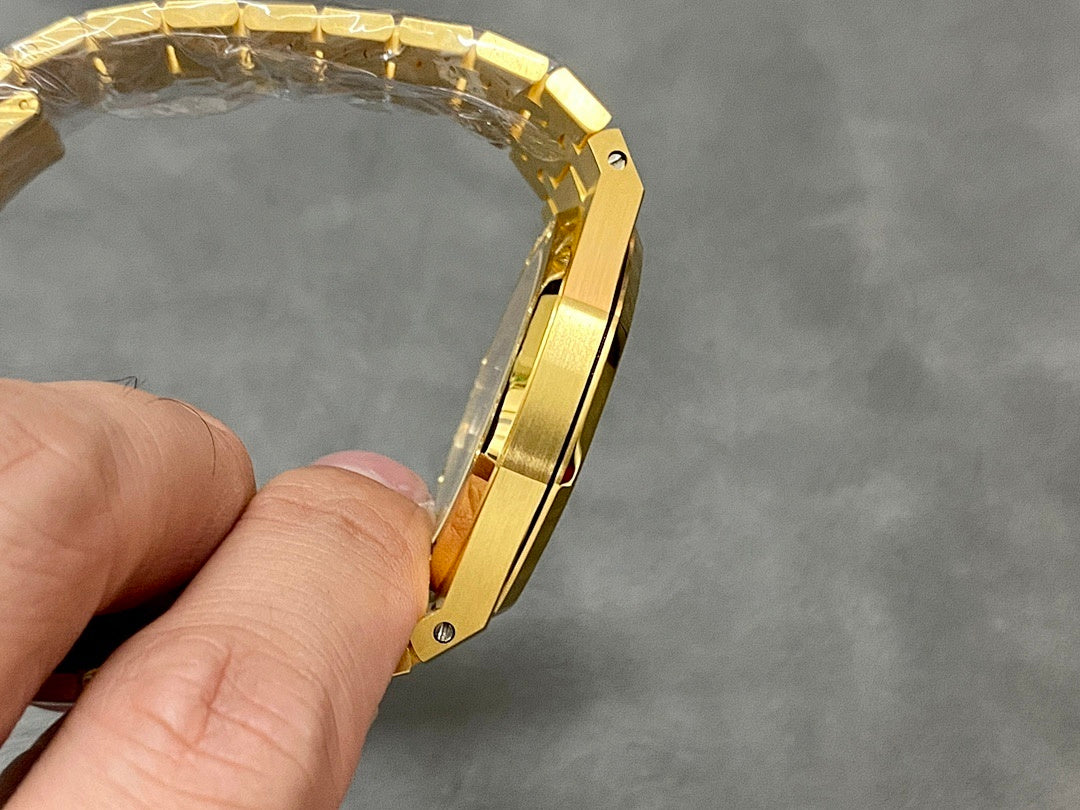 Gold-tone luxury wristwatch bracelet links held in hand