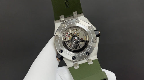 Audemars Piguet watch with exposed mechanical back, green rubber strap and steel case