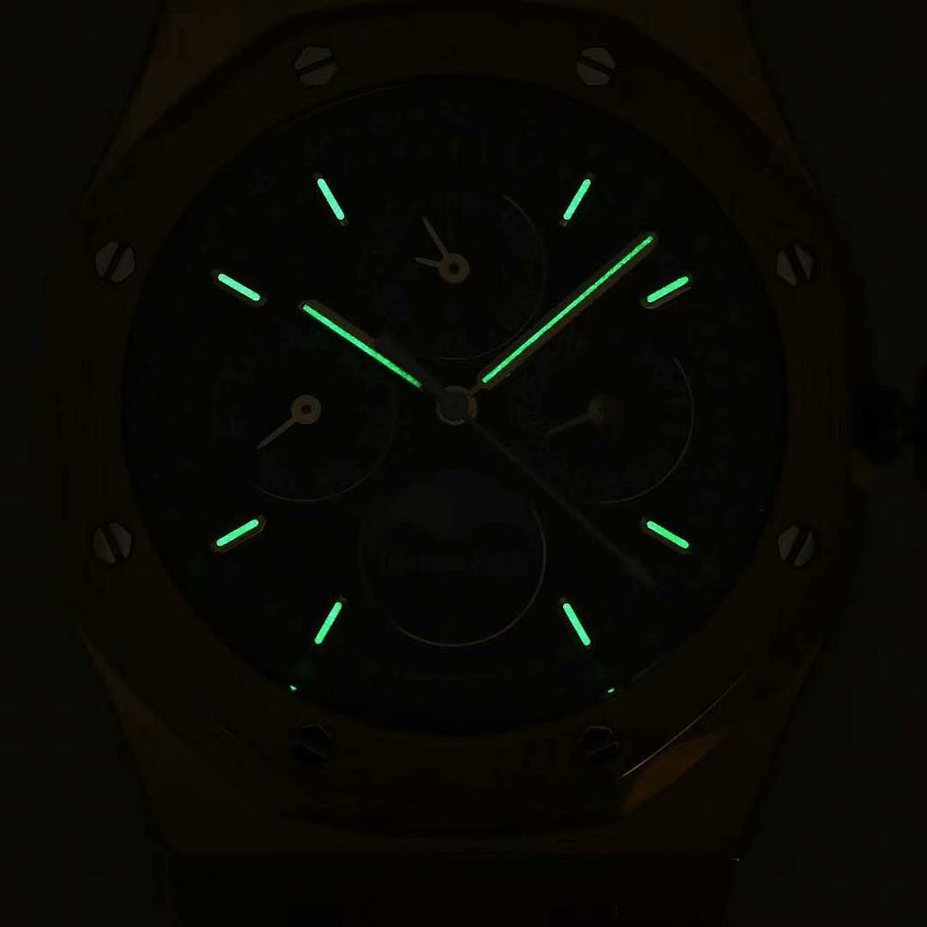 Wristwatch face with dark blue dial and glowing green markers and hands