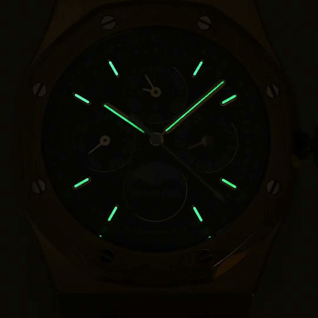 Wristwatch face with dark blue dial and glowing green markers and hands