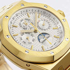 Close-up of gold-tone watch dial with day-month text rings, gold markers, and moon subdial