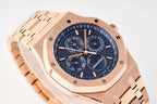 Rose gold-tone wristwatch dial close-up with blue textured center and subdial hands.