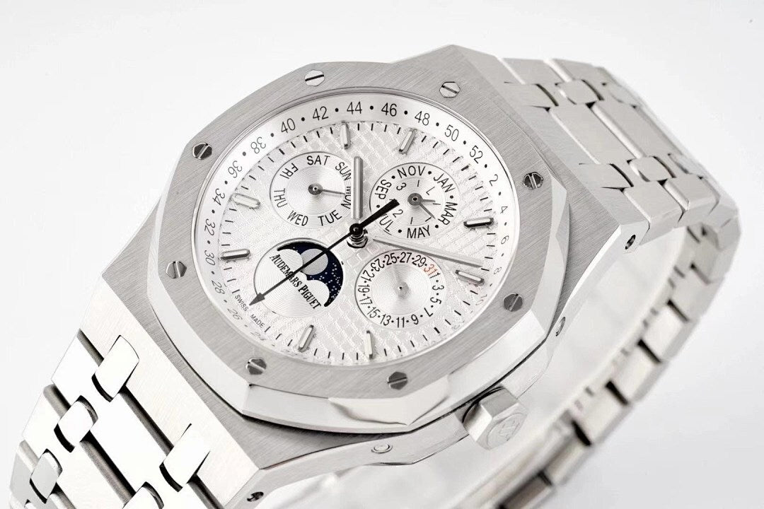 Stainless steel watch close-up with white dial, subdials, and day/date text