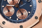Blue chronograph dial with rose-gold subdials, tachymeter markings, and steel hands.