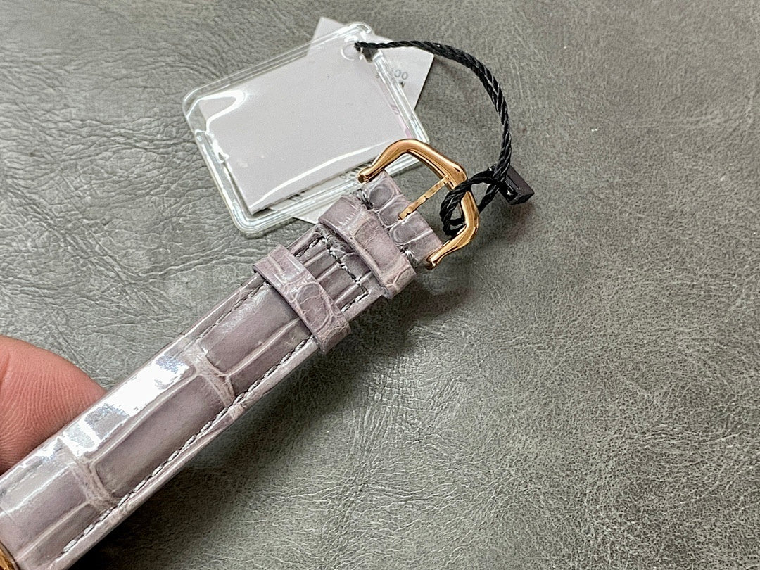 Round watch with gray leather strap, gold-tone clasp and hanging tag