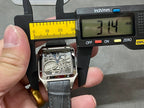 Square skeleton watch on a measuring tool, silver-tone case with black leather strap
