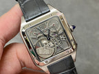 Square skeleton watch face with silver-tone case and black leather strap in hand