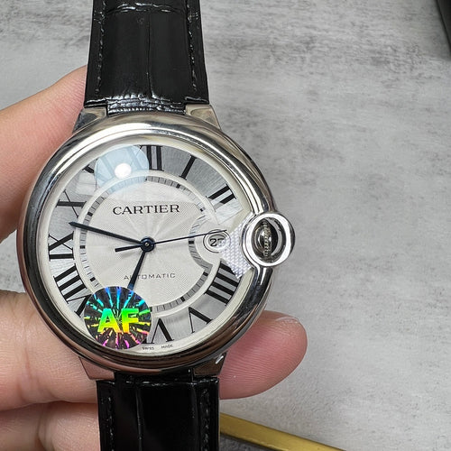 Round wristwatch with silver case, black leather strap; white dial and crown at 3 o'clock.