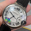 Round wristwatch: silver-tone case, black leather strap; white dial with Roman numerals.
