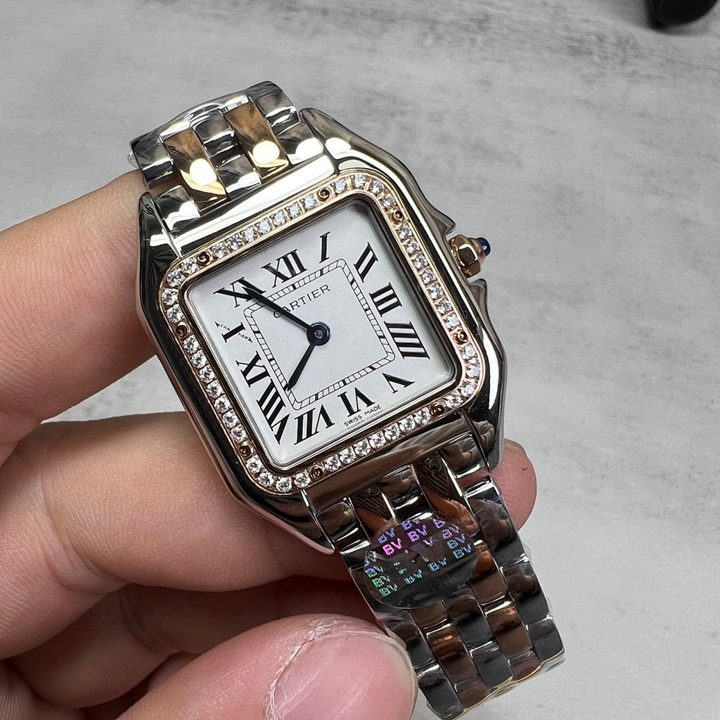 Cartier watch close-up of rectangular face, Roman numerals, diamond bezel, silver-and-gold links