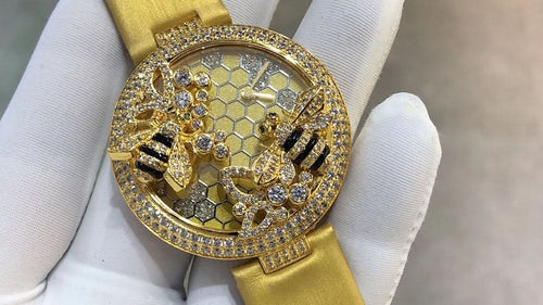 Cartier watch with gold-tone strap and round bezel, honeycomb dial with black accents and gems