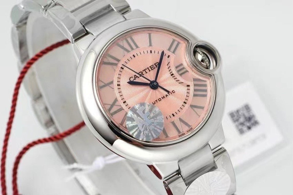 Cartier watch close-up: light pink dial, roman numerals, silver bezel and crown
