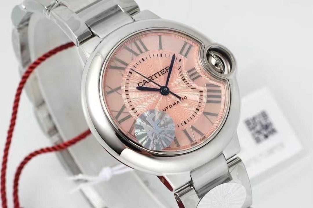 Cartier watch close-up: light pink dial, roman numerals, silver bezel and crown