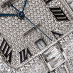 Close-up of diamond dial with Roman numerals, blue hands, and watch crown details.