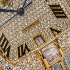 Cartier watch dial close-up with diamond pavé, Roman markers, and “AUTOMATIC” text.