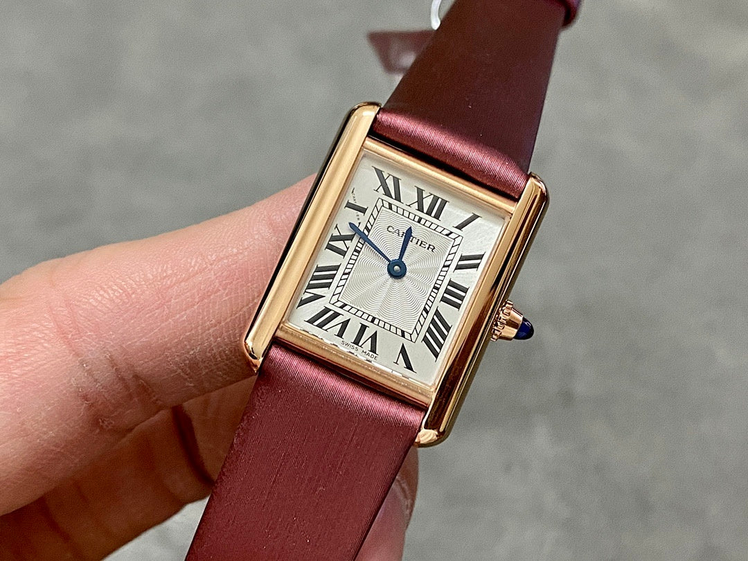 Cartier rectangular wrist watch with burgundy leather strap, gold case, white Roman dial