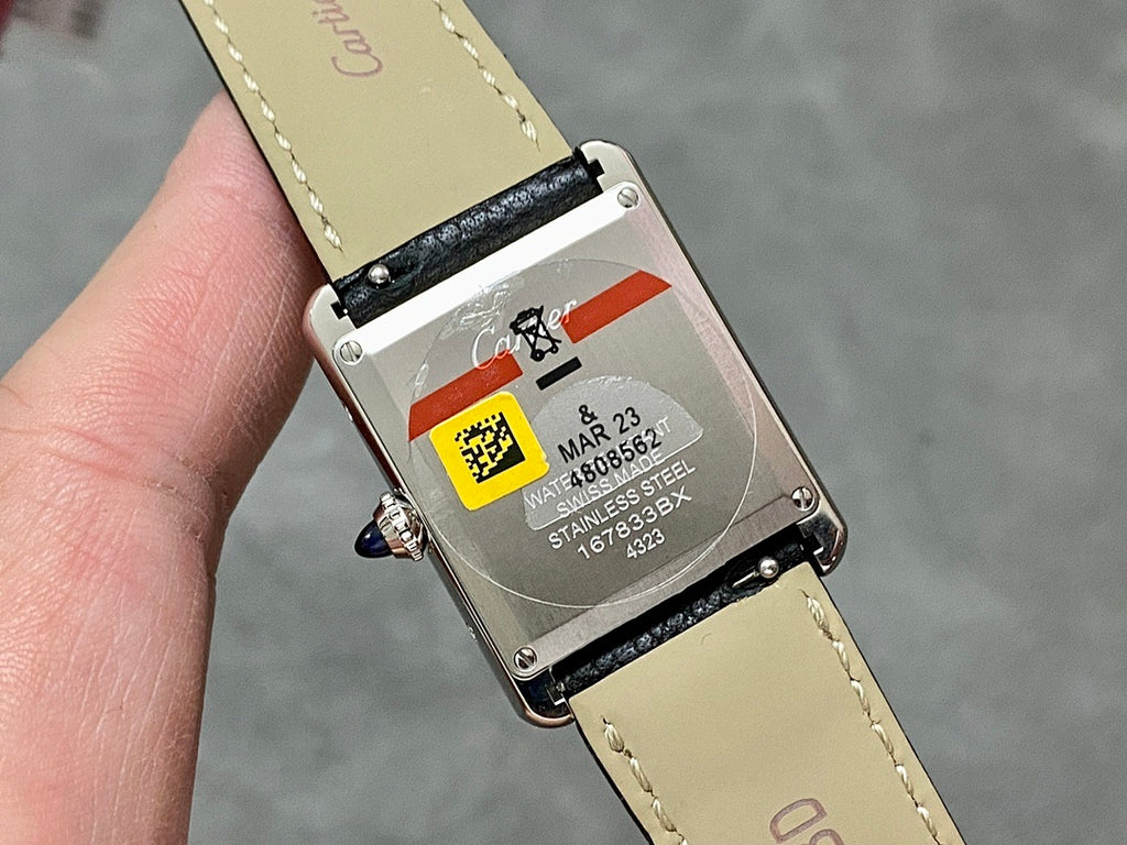 Rectangular watch caseback with screws, QR label, and engraved serial markings.