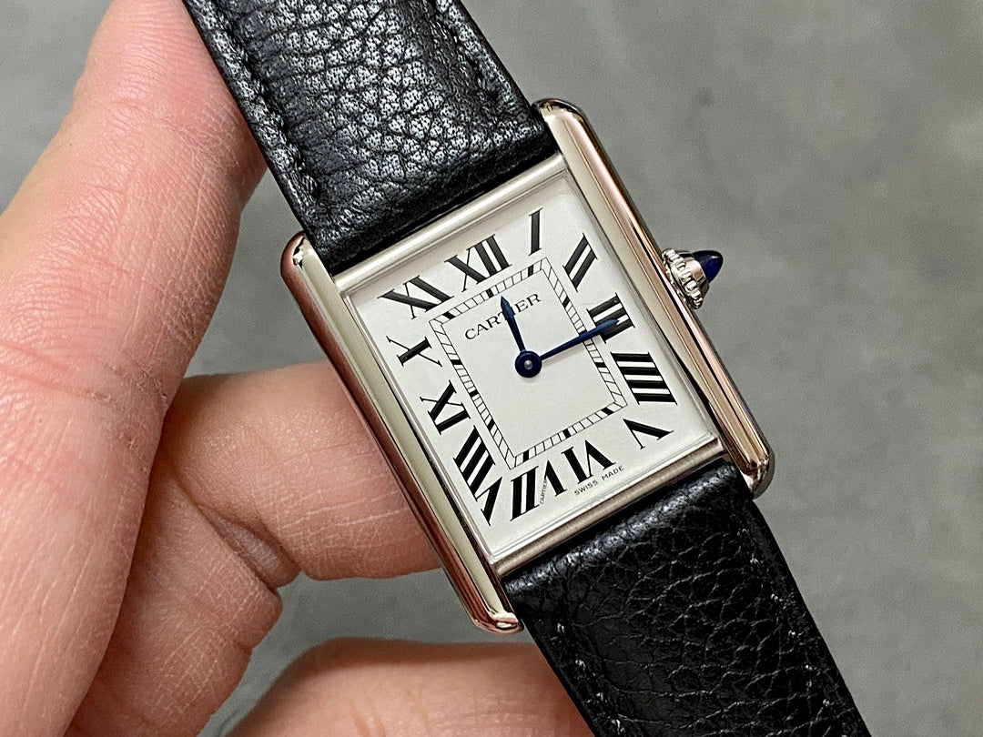 Rectangular watch with black leather strap, white face, Roman numerals, blue center hands.