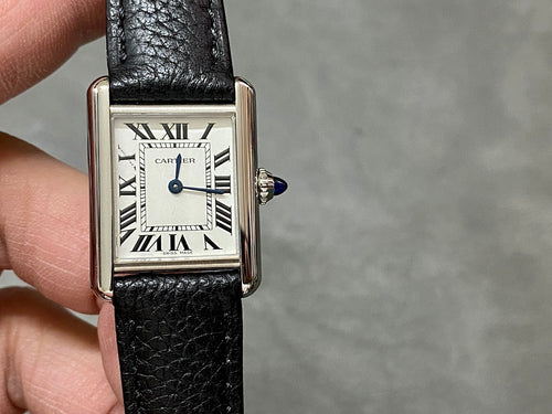 Cartier watch front view, Roman numeral dial, black leather strap, polished metal case