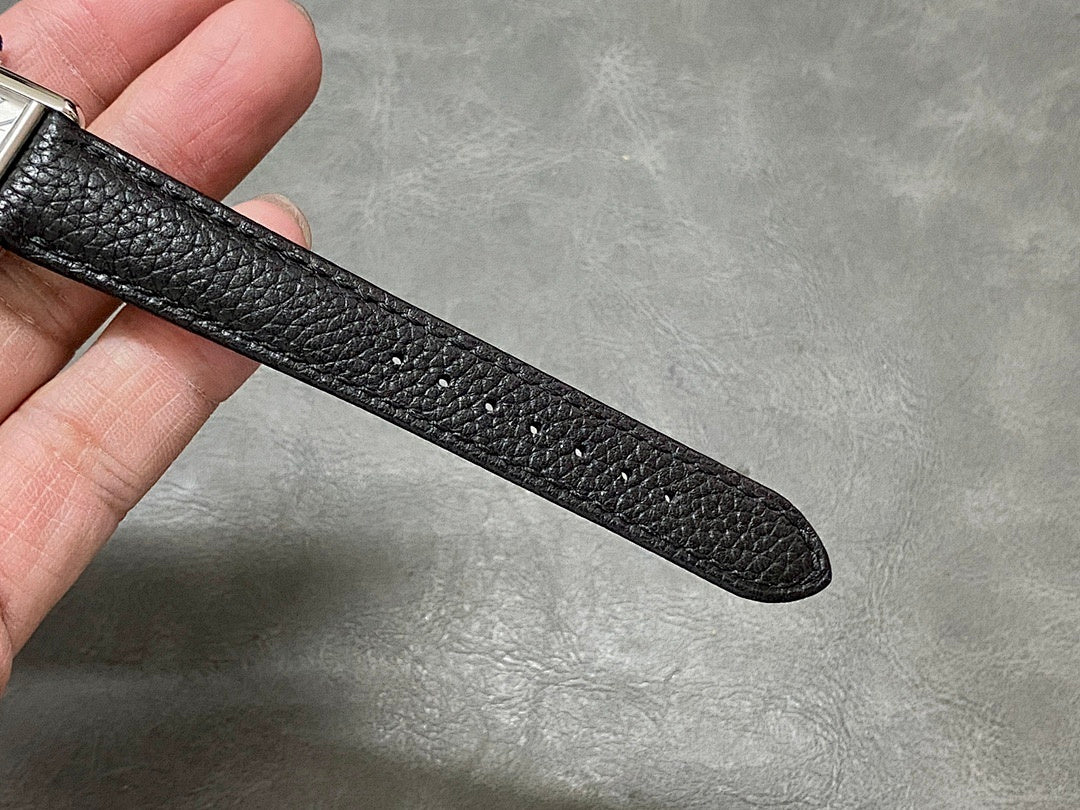 Black leather watch strap with pebbled texture, curved end band visible