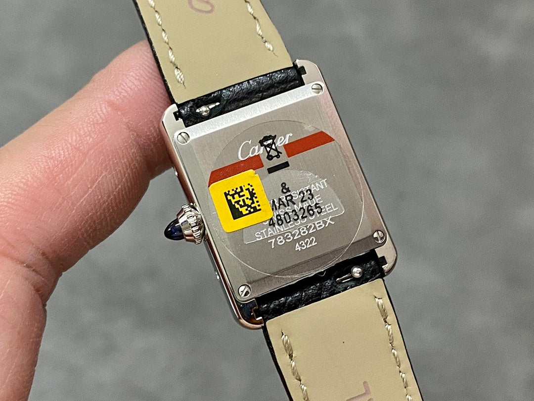 Watch case back with serial-style markings, black strap and cream leather lining