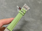 Green leather watch strap with metal buckle and clasp hardware