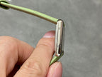 Cartier watch side view with polished case and green leather strap