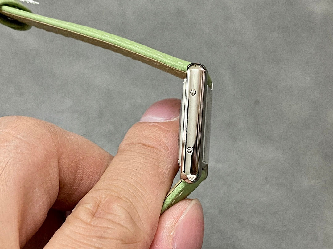 Cartier watch side view with polished case and green leather strap