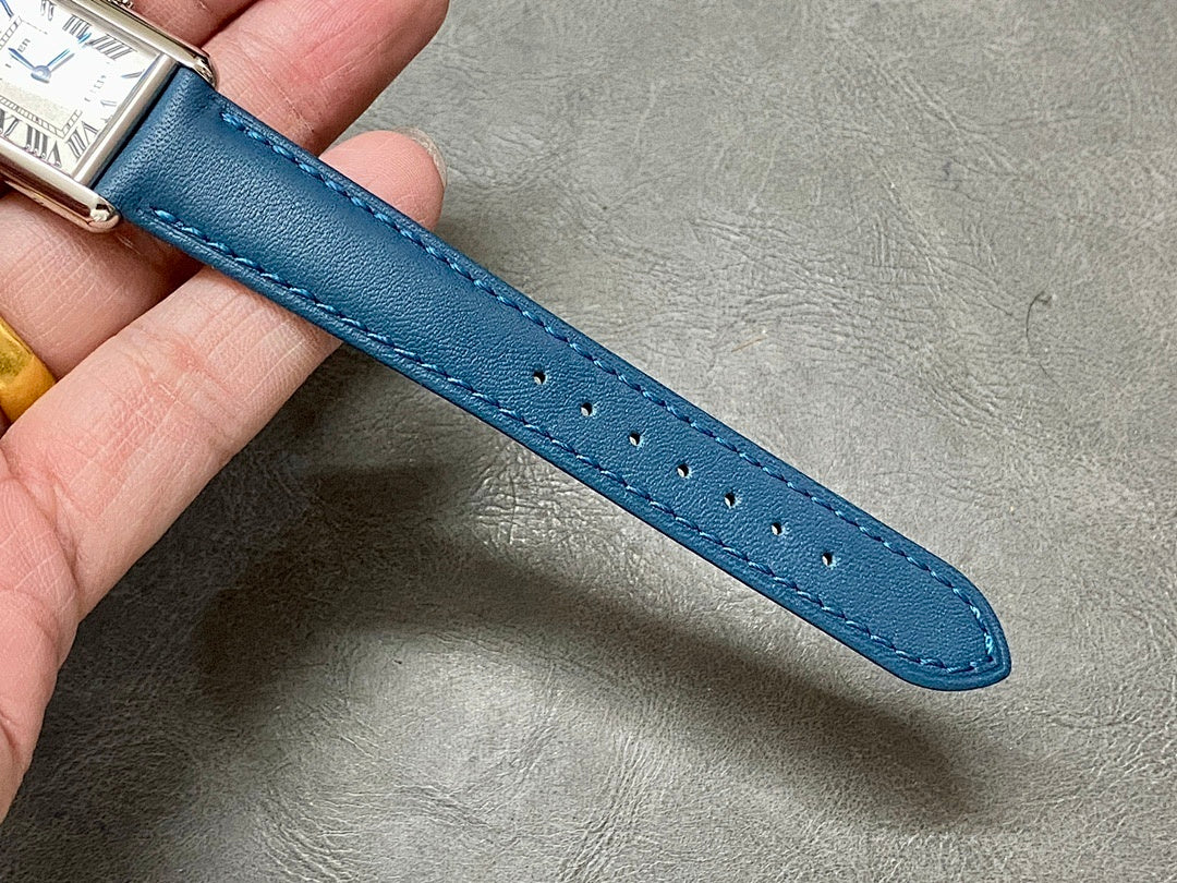 Blue leather watch strap with stitched edge and punched holes.