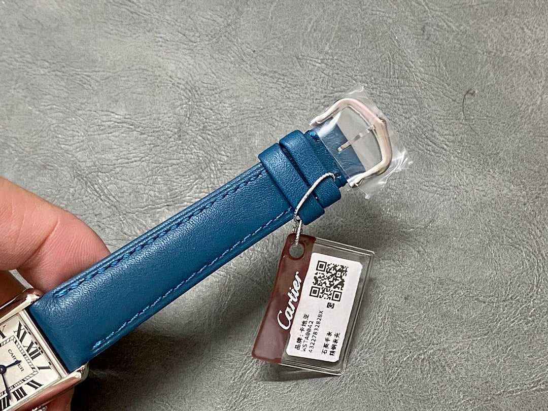 Blue leather watch strap with metal buckle and hanging tag.